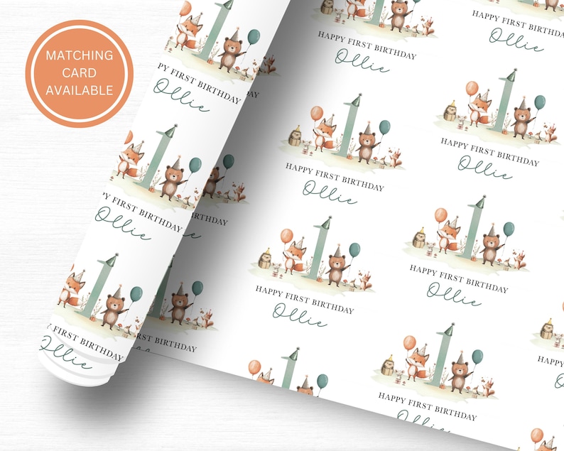 May include: White wrapping paper with a repeating pattern of a fox, bear, and number one with the text "Happy First Birthday Ollie" in a handwritten font.