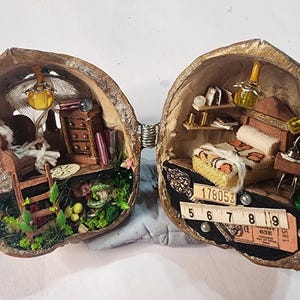 Pode incluir: Um diorama em miniatura dentro de uma casca de noz dividida com dois cômodos. O lado esquerdo contém uma cadeira, cômoda e escada. O lado direito apresenta uma cama, prateleiras e uma régua com os números 5 a 9, e um bilhete com 178053.