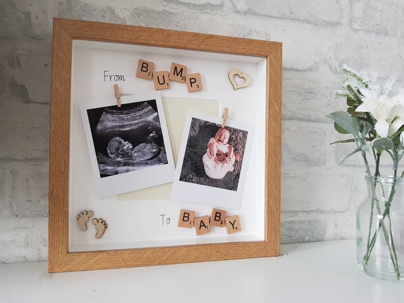 Pu&ograve; includere: Una cornice in legno con due foto, un'ecografia e una di un bambino. Tessere di legno con la scritta "From Bump To Baby". Accenti decorativi a forma di cuore e piedini di bambino in legno completano il design.