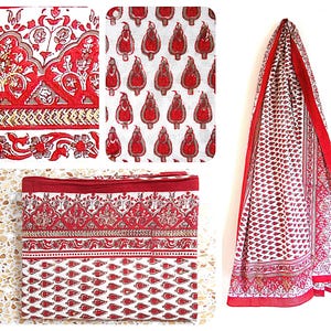 Peut inclure: Tissu en coton rouge et blanc avec un imprimé paisley. Le tissu a une bordure dorée et est présenté plié en forme de carré.