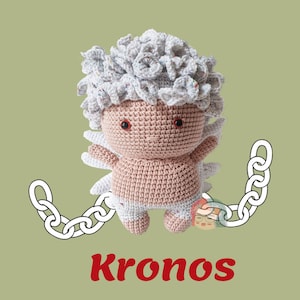 May include: A crocheted toy of the Greek god Kronos, depicted as a baby with a white curly wig and pink skin. He is wearing a white diaper and has a chain attached to his legs. The word "Kronos" is written in red below the toy.