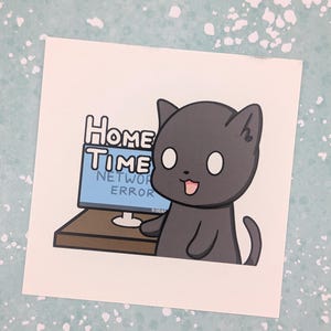以下が含まれることがあります： 茶色のデスクでコンピューターモニターの前に座っている、ダークグレーの漫画の猫が描かれた正方形のステッカー。画面には青と白で「HOME TIME」と「NETWORK ERROR」という文字が表示されており、隅には小さな9:00AMというタイムスタンプがあります。