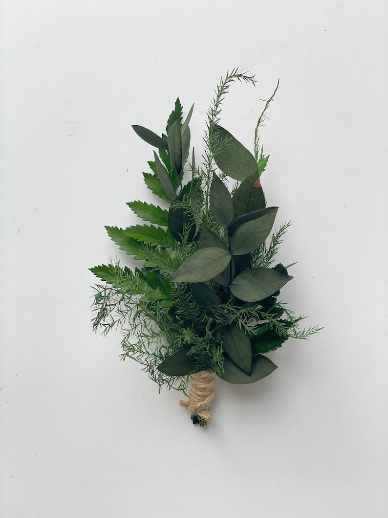 May include: A small bouquet of green foliage tied with twine. The bouquet includes ferns, eucalyptus, and other greenery.