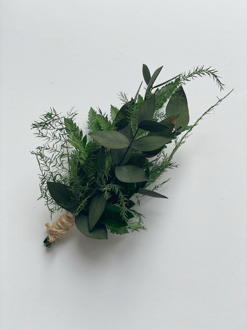May include: A small bouquet of green foliage tied with twine. The bouquet includes eucalyptus, ferns, and other greenery.