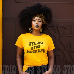 May include: A woman wearing a yellow t-shirt with the text "STUDIO 3703 MOCKUPS" printed on it. She is wearing a black headband and has curly black hair.