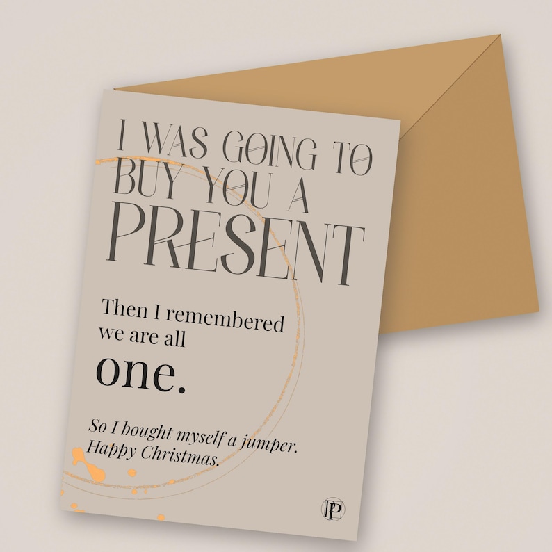 Peut inclure: Une carte de v&oelig;ux beige avec une enveloppe marron clair portant le texte : I WAS GOING TO BUY YOU A PRESENT. Then I remembered we are all one. So I bought myself a jumper. Happy Christmas. Un motif circulaire orange p&acirc;le est visible.
