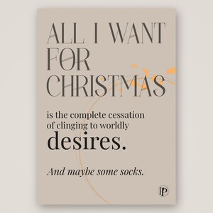 Peut inclure: Une impression rectangulaire sur fond beige clair avec un texte gris foncé : ALL I WANT FOR CHRISTMAS is the complete cessation of clinging to worldly desires. And maybe some socks. Un léger motif circulaire orange est visible.