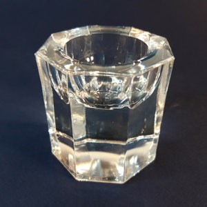 May include: A clear glass dish with a hexagonal base and a rounded bowl. The dish is perfect for holding small items, such as jewelry or trinkets.