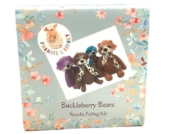 Op de afbeelding: Een naaldvilten set met vijf schattige vilten beren in verschillende kleuren, waaronder bruin, paars, blauw en grijs. De set heeft de titel "Buckleberry Bears Needle Felting Kit" en bevat een logo met de tekst "Frankie & Sidney".