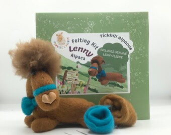 Op de afbeelding: Een viltset om een ​​bruine alpaca genaamd Lenny te maken. De set bevat een bol bruine alpaca vlies, een bol turquoise blauwe wol, twee vilten naalden en een doos met een afbeelding van een bruine alpaca. De doos heeft de tekst "Felting Kit Lenny Alpaca" en "Includes Genuine Lenny Fleece".