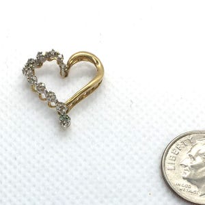 May include: A gold heart-shaped pendant with a row of small diamonds around the edge.
