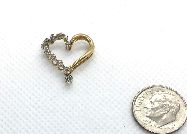 May include: A gold heart-shaped pendant with a row of small diamonds around the edge.