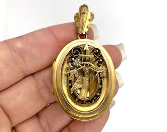 May include: An oval gold locket pendant featuring a central relief of a bird perched on a branch with a small flower made of tiny white pearls. The locket has an ornate bail at the top and decorative scrollwork surrounding the bird motif.