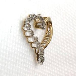 May include: A gold heart-shaped pendant with a diamond-encrusted design. The pendant features the word "LOVE" inscribed on the side.