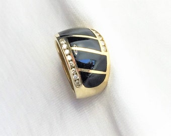May include: A gold ring with black enamel and a row of clear stones around the band.