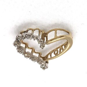May include: A gold heart-shaped ring with a row of small diamonds around the edge.