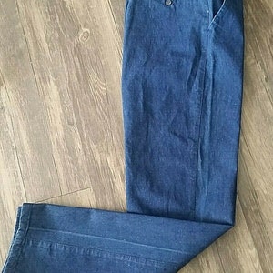 Pu&ograve; includere: Un paio di pantaloni di jeans blu scuro con zip e un solo taschino posteriore.