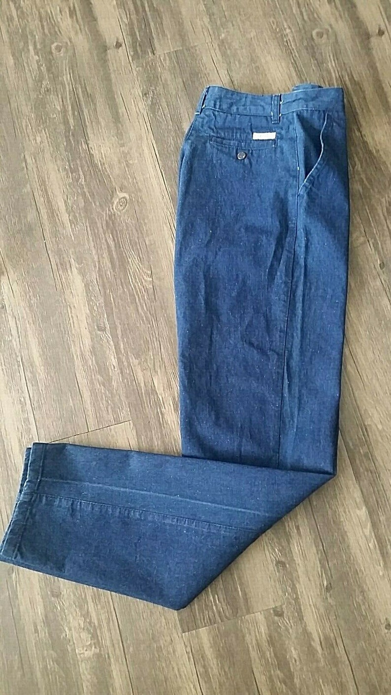 Pu&ograve; includere: Un paio di pantaloni di jeans blu scuro con zip e un solo taschino posteriore.