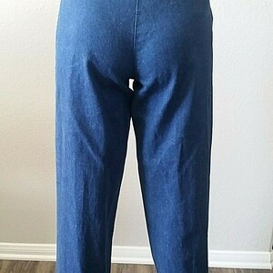 Pu&ograve; includere: Un paio di pantaloni di jeans blu scuro a gamba dritta. I pantaloni hanno una chiusura con bottoni e passanti per la cintura.