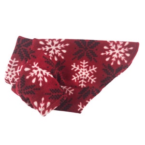 May include: Red fleece dog sweater with a white snowflake pattern.