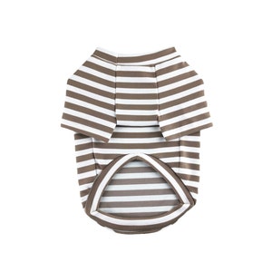 May include: A brown and white striped dog shirt with short sleeves.