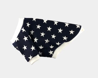 May include: A navy blue dog sweater with a white star pattern. The sweater has a white trim around the neck and sleeves.