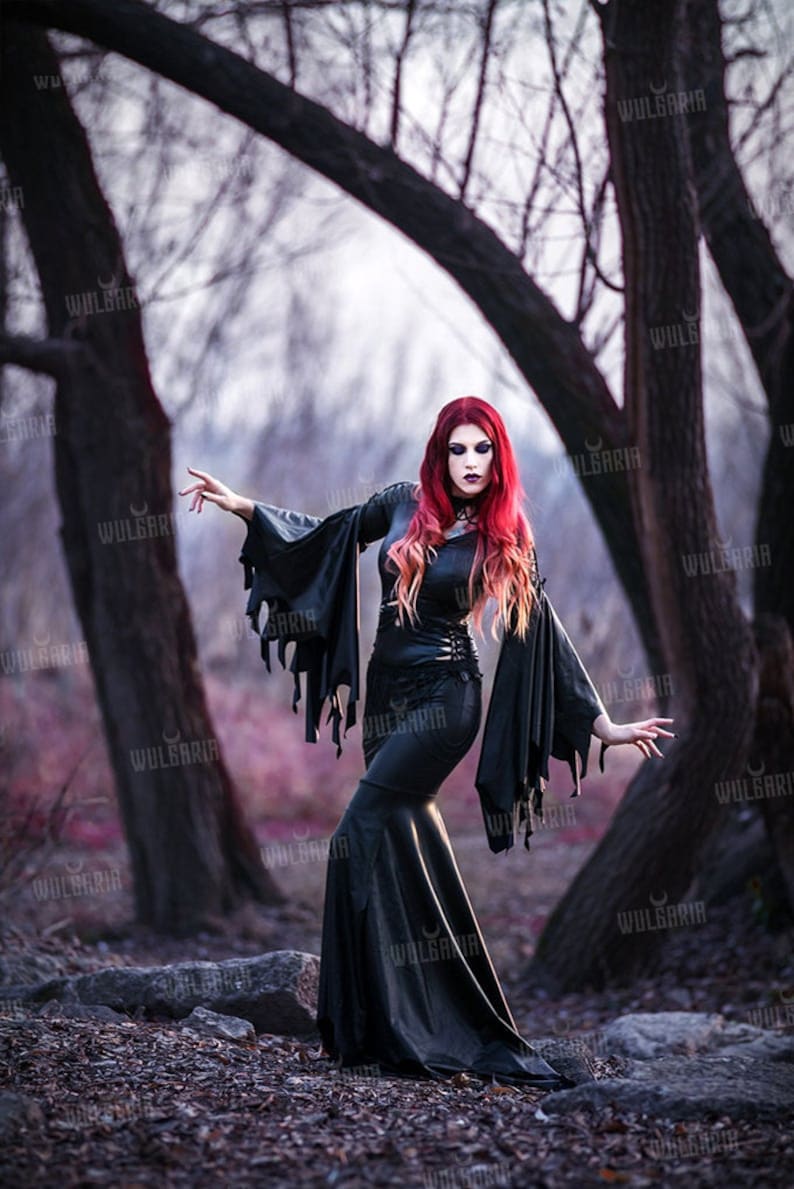 Model posing in dark fantasy gown in autumn woods
