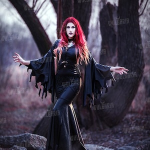 Model wearing gothic black gown in misty forest