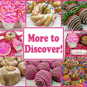 May include: A collage of images showcasing various bath and body products, including cupcakes, donuts, cinnamon rolls, and chocolate truffles. The products are decorated with colorful sprinkles and frosting. The text "More to Discover!" is displayed in the center of the collage.