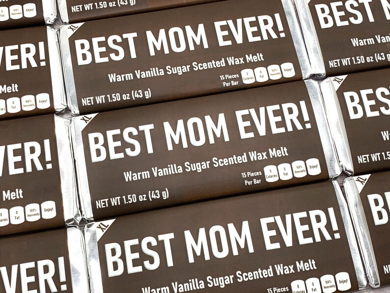 May include: A close-up of several brown wax melt bars with silver foil wrappers. The bars are labeled "Best Mom Ever!" and "Warm Vanilla Sugar Scented Wax Melt". Each bar is 1.50 ounces (43 grams).