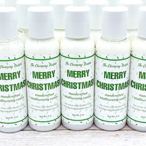 May include: A collection of white lotion bottles with white caps. Each bottle has a label with "MERRY CHRISTMAS" in green text, along with the words "Handcrafted Moisturizing Lotion". The labels are decorated with green and red confetti.