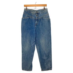 May include: High-waisted blue denim jeans with a button fly and a unique design featuring angled pockets and seams.