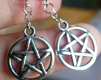 May include: Silver earrings with a pentagram charm. The pentagram is a five-pointed star within a circle.