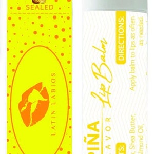 May include: A yellow and white lip balm tube with the words "PIÑA Lip Balm" and "FLAVOR" printed on the tube. The ingredients are listed on the tube: Candellila Wax, Shea Butter, Coconut Oil, Almond Oil. The directions are also listed: Apply balm to lips as often as needed.