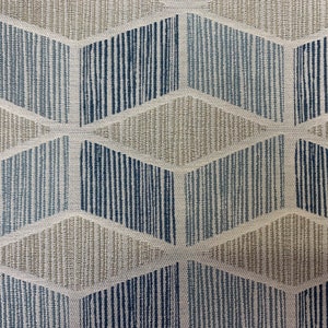 May include: A close-up of a fabric with a geometric pattern. The pattern is made up of blue and beige stripes that form a series of overlapping diamonds.