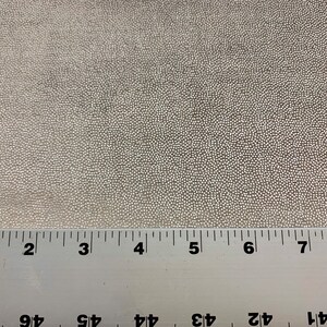 May include: Close-up of a white fabric with a textured surface. A ruler is placed at the bottom of the image with markings from 1 to 8 inches.