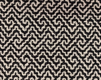 May include: Black and white fabric with a wavy, abstract pattern. The pattern is made up of small, repeating shapes that create a sense of movement.