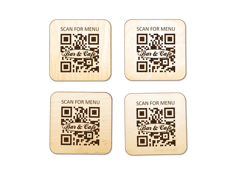 Puede incluir: Cuatro posavasos cuadrados de madera clara, cada uno con un c&oacute;digo QR grabado a l&aacute;ser en color marr&oacute;n oscuro. Sobre el c&oacute;digo QR, el texto dice SCAN FOR MENU, y centrado dentro del c&oacute;digo QR aparece el texto Bar & Cafe en cursiva.