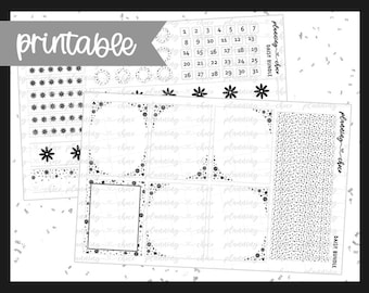 May include: A black and white printable planner sticker set with floral and snowflake designs. The set includes calendar numbers, decorative borders, and various embellishments. The word "printable" is at the top left.