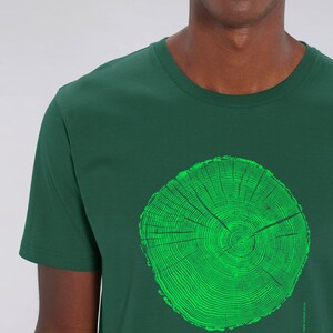 May include: A dark green t-shirt with a bright green tree ring graphic and the text "arbor master" printed on the front.