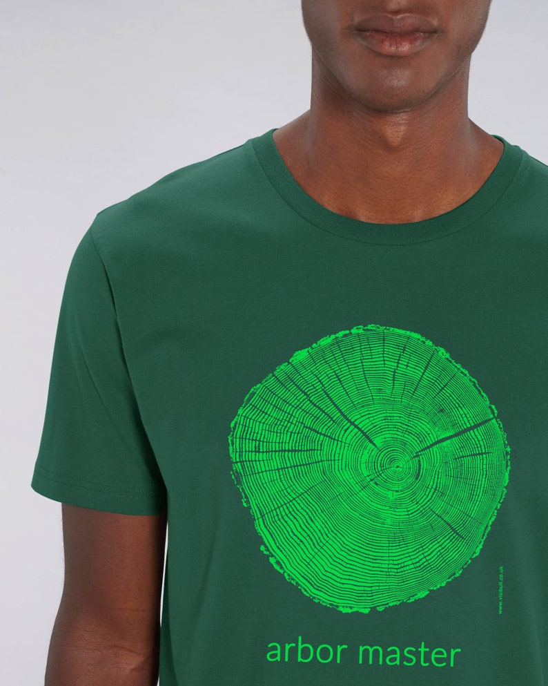 May include: A dark green t-shirt with a bright green tree ring graphic and the text "arbor master" printed on the front.