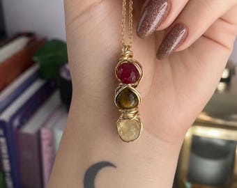 Ciondolo unico in oro con cristallo avvolto in filo metallico, segno zodiacale Leone.