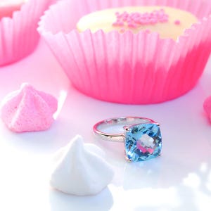 Bague Solitaire argent 925 rhodié sertie d'une topaze bleue coussin