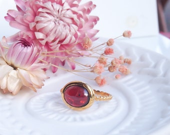 Golden silver and red garnet oval cabochon ring