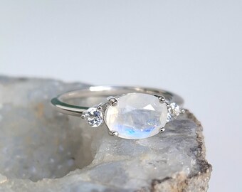 Bague argent 925 rhodié sertie d'une pierre de lune ovale et deux topazes incolores