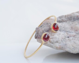 Open bangle bracelet in 925 silver with yellow gold plating set with 2 cabochon red garnets