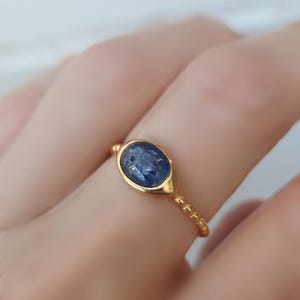 Gold-plated silver ring set with a small oval cabochon cyanite