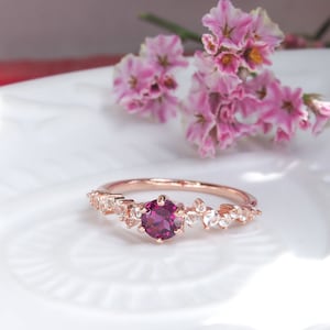 Rose gold plated silver ring, round rhodolite garnet and small colorless topazes on the band