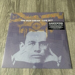 May include: A vinyl record album cover for "The Iron Dream - Live 1977" by Hawkwind. The cover features a stylized portrait in shades of purple and gold, with the band's name and album title prominently displayed. The album is an exclusive Record Store Day release.