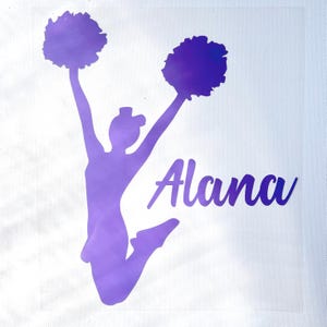 May include: A purple vinyl decal featuring a silhouette of a cheerleader jumping with pom-poms held high in the air. The design includes the name Alana written in a cursive script font to the right of the jumping figure on a clear backing.